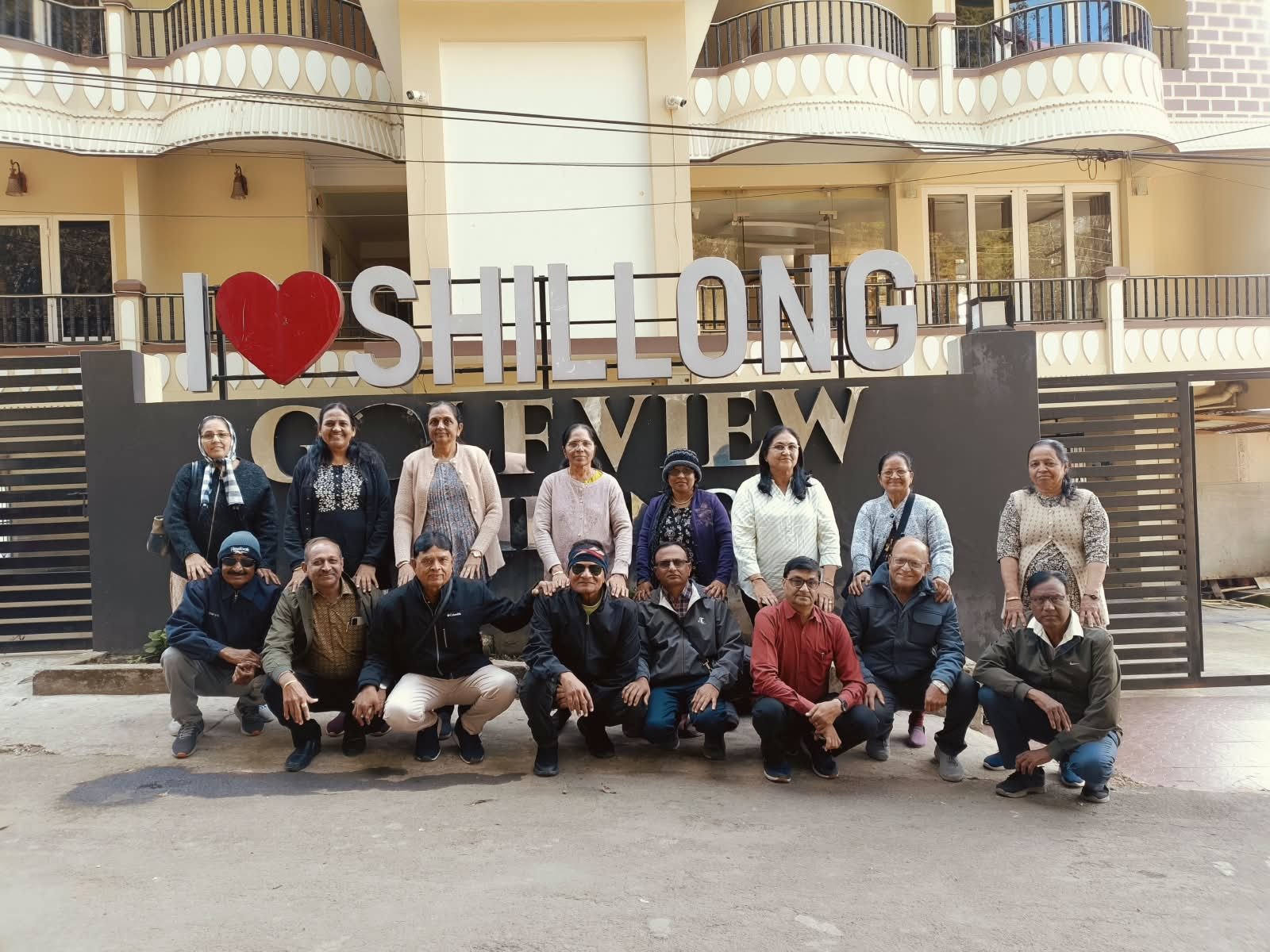 A travel group posing beside an I Love Shillong sign