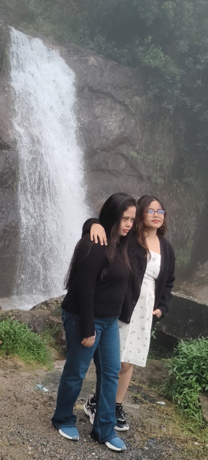 Travellers standing beside a waterfall