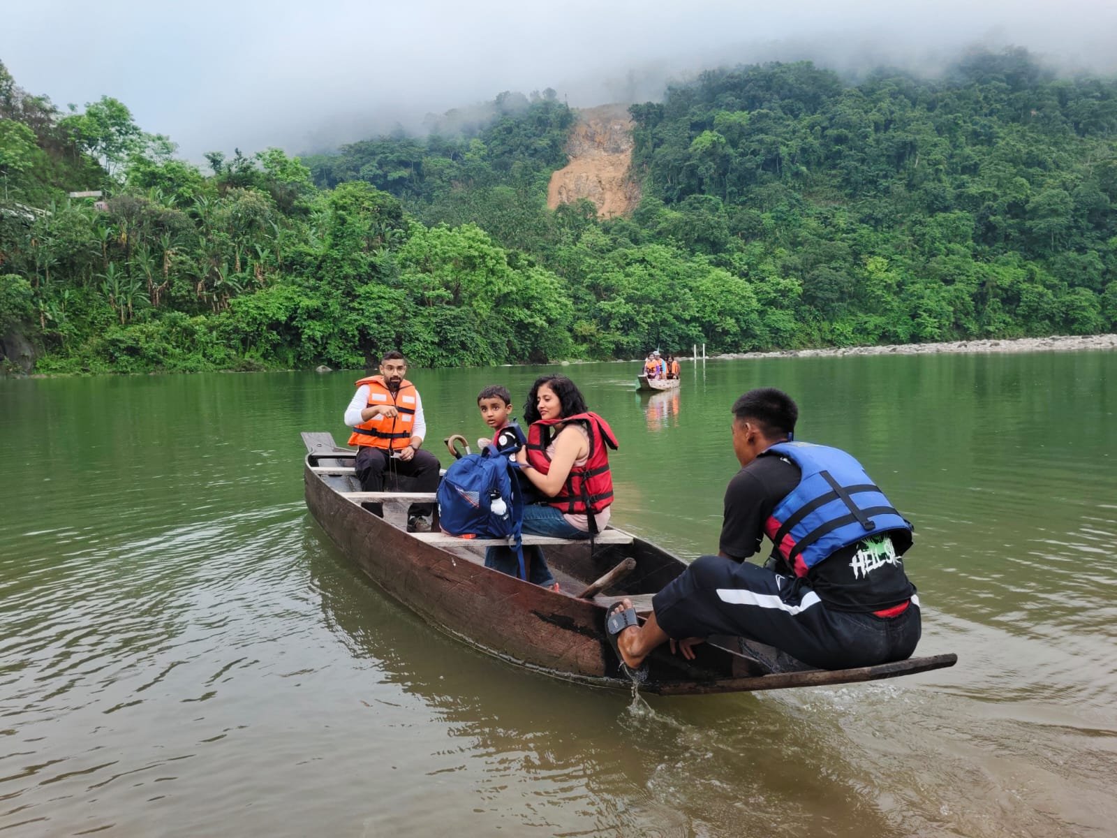 Travellers enjoying a boat journey surrounded by green hills